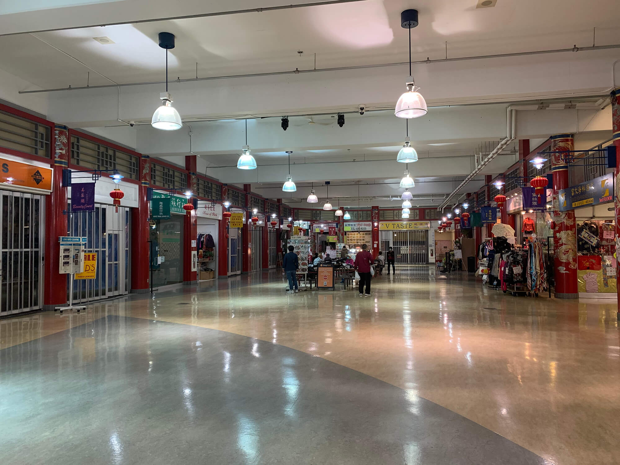 Inside the Chinatown Plaza, only two shops remain open, while the rest have put up their shutters and locked their doors. Under the fluorescent overhead lights, a few patrons sit and stand near the small food court.