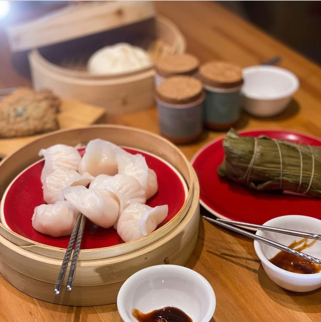 Image of shrimp dumplings in a bamboo steamer and other dim sum items